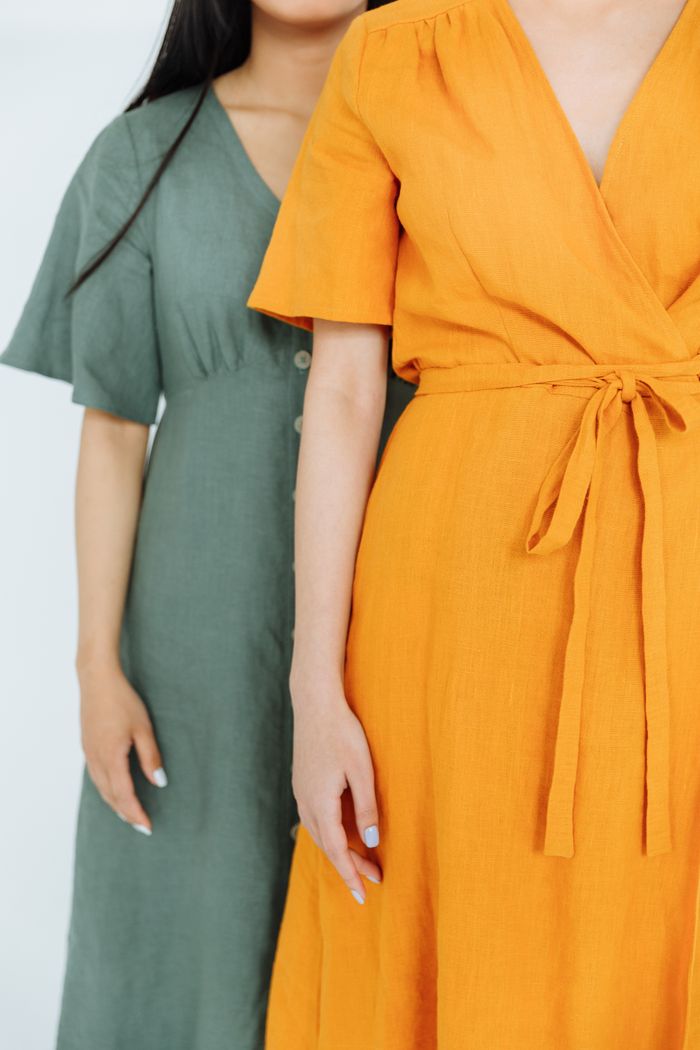 Close-up of two women in vibrant dresses, highlighting modern fashion style.
